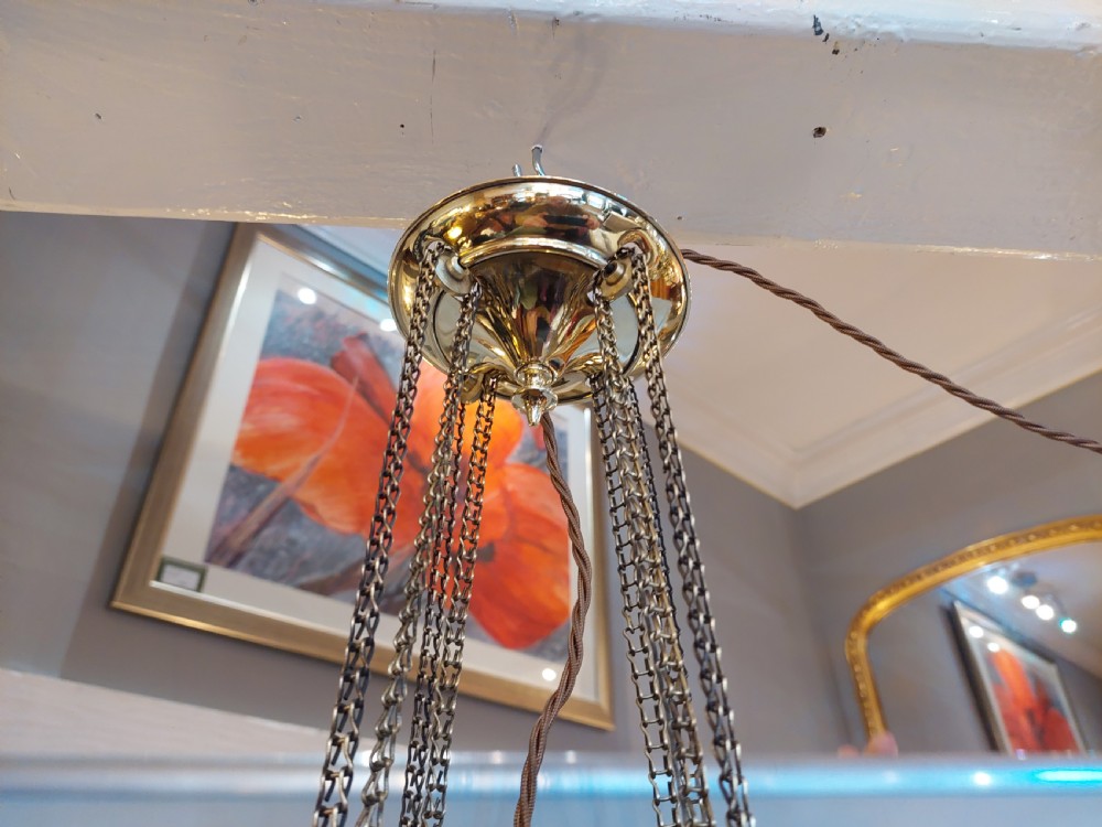 A Victorian hanging brass lantern with rectangular leaded glass panels displaying diamond motifs and suspended by delicate chains. View VI