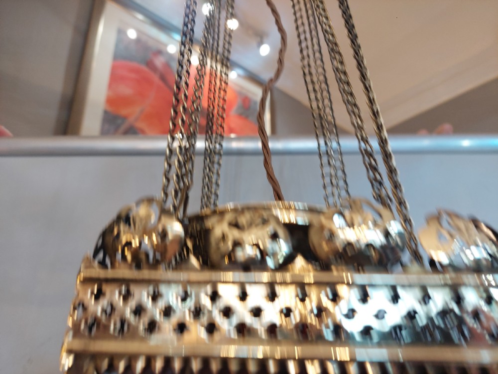 A Victorian hanging brass lantern with rectangular leaded glass panels displaying diamond motifs and suspended by delicate chains. View VII
