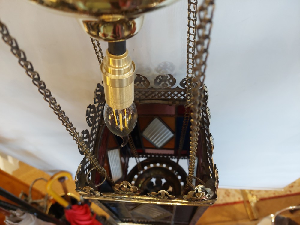 A Victorian hanging brass lantern with rectangular leaded glass panels displaying diamond motifs and suspended by delicate chains. View VIII