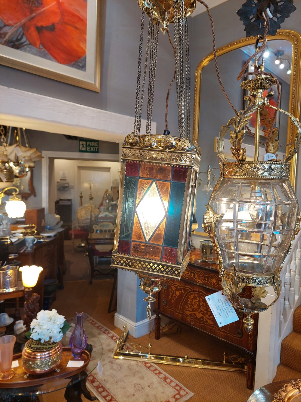 A Victorian hanging brass lantern with rectangular leaded glass panels displaying diamond motifs and suspended by delicate chains. View X