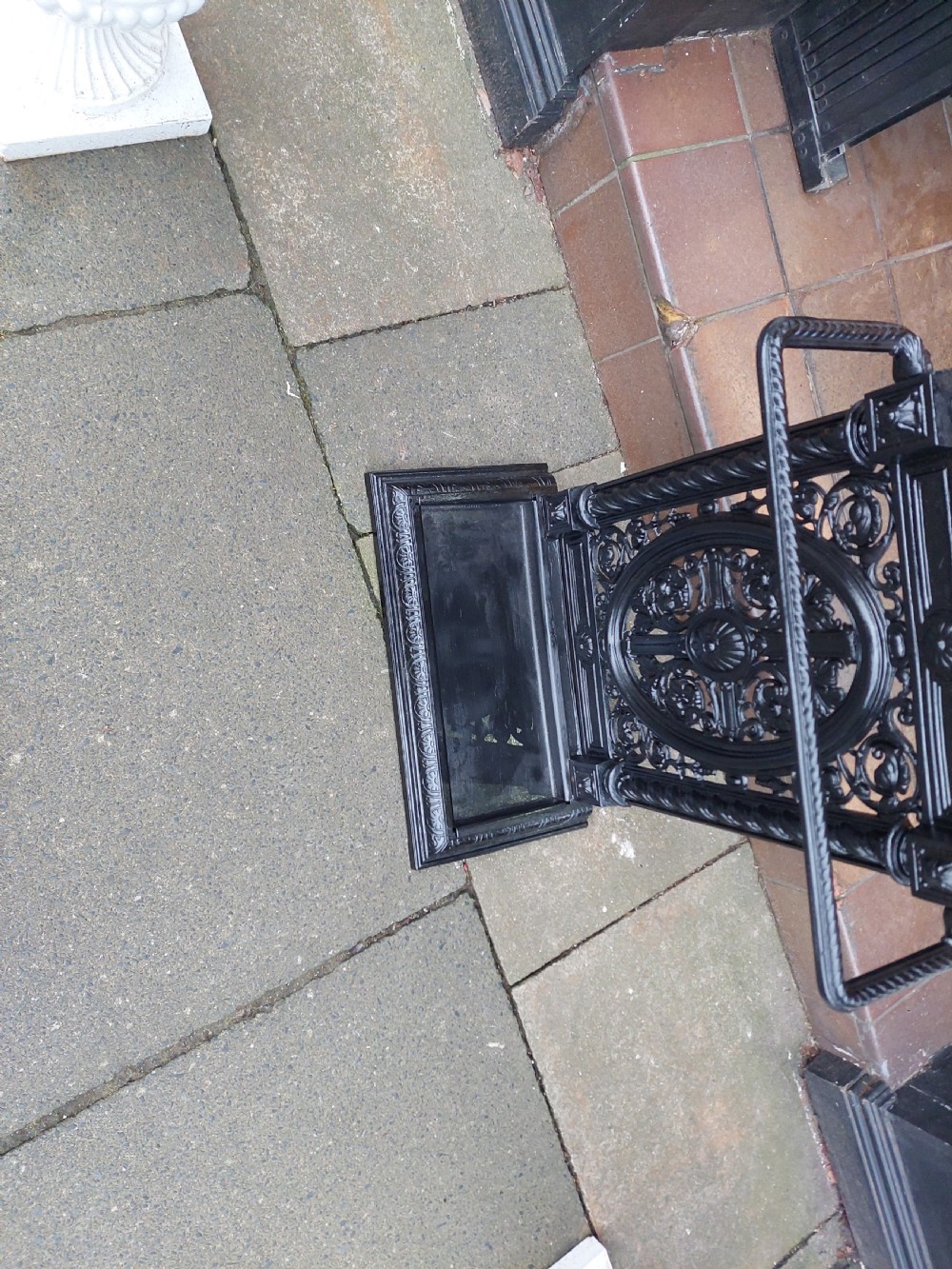 A black painted cast iron stick stand featuring elaborate foliate scrollwork, twisted rope columns, and a removable drip tray base. View III
