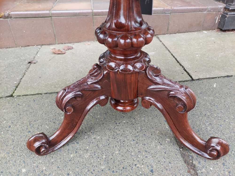 A late Victorian revolving piano stool featuring a carved rosewood tripod base and a circular padded seat with floral embroidery. View III