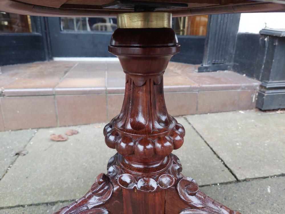 A late Victorian revolving piano stool featuring a carved rosewood tripod base and a circular padded seat with floral embroidery. View VI