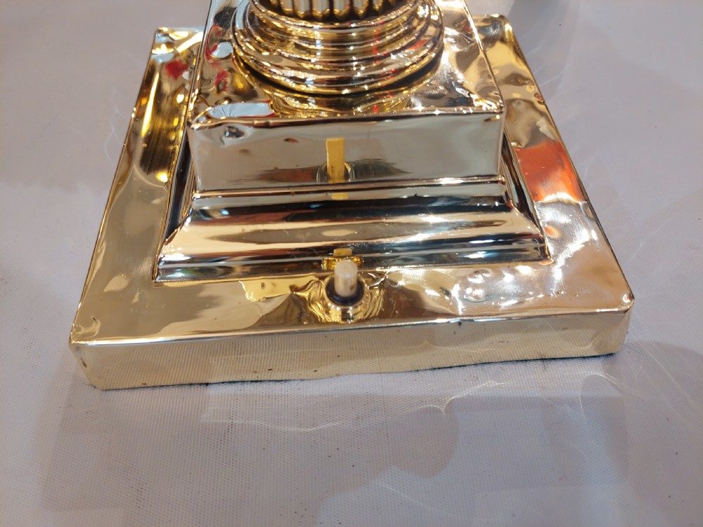 An early 20th-century brass Corinthian column table lamp with a stepped square base and a dome-shaped patterned silk shade featuring fringed tassels. View IV