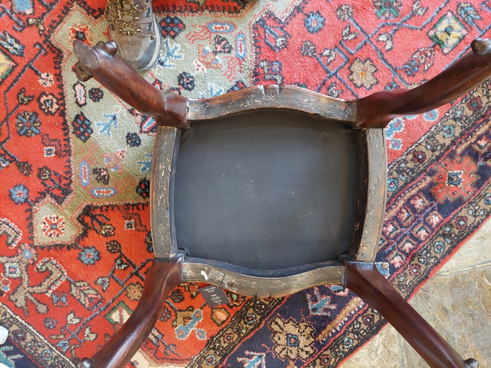 A Victorian mahogany stool featuring dark buttoned black leather upholstery with brass studding and four carved cabriole legs. View VII