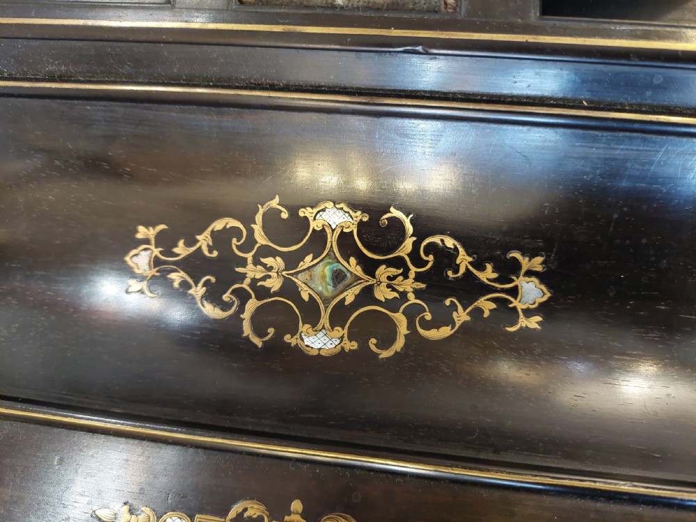A mid-19th-century dark coromandel wood inkstand desk tidy featuring floral inlay, a pen trough, two lidded compartments, and a central glass inkwell. View V