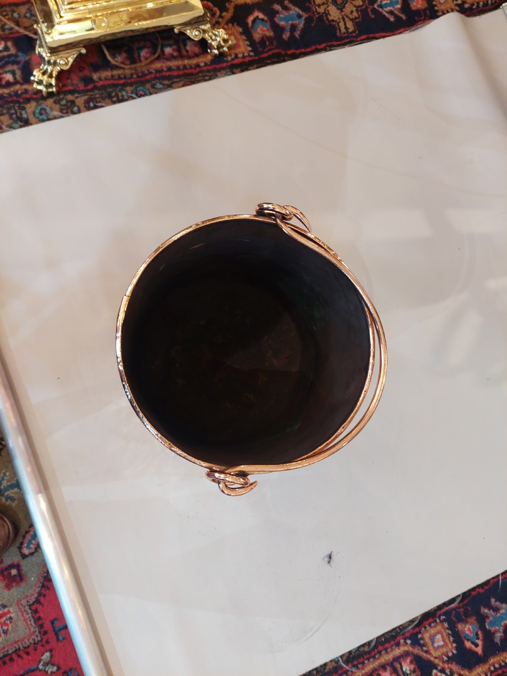A cylindrical copper coal bucket featuring vertical riveted seams and metallic carrying rings attached to the upper rim. View III
