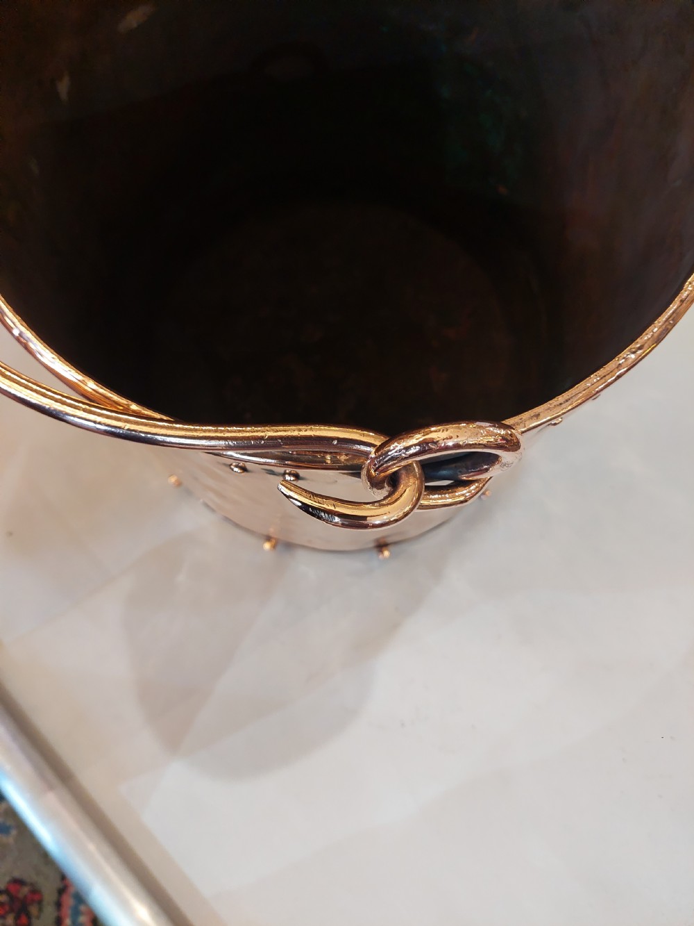 A cylindrical copper coal bucket featuring vertical riveted seams and metallic carrying rings attached to the upper rim. View IV