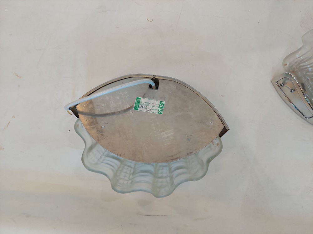 A three-piece Art Deco lighting suite comprising a hanging central shell pendant light and two matching wall sconces made of moulded frosted glass set in chrome mounts. View VI