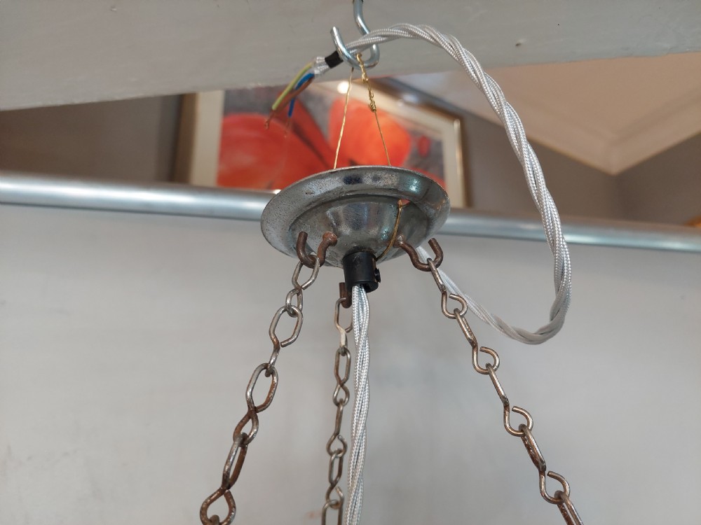 A three-piece Art Deco lighting suite comprising a hanging central shell pendant light and two matching wall sconces made of moulded frosted glass set in chrome mounts. View X