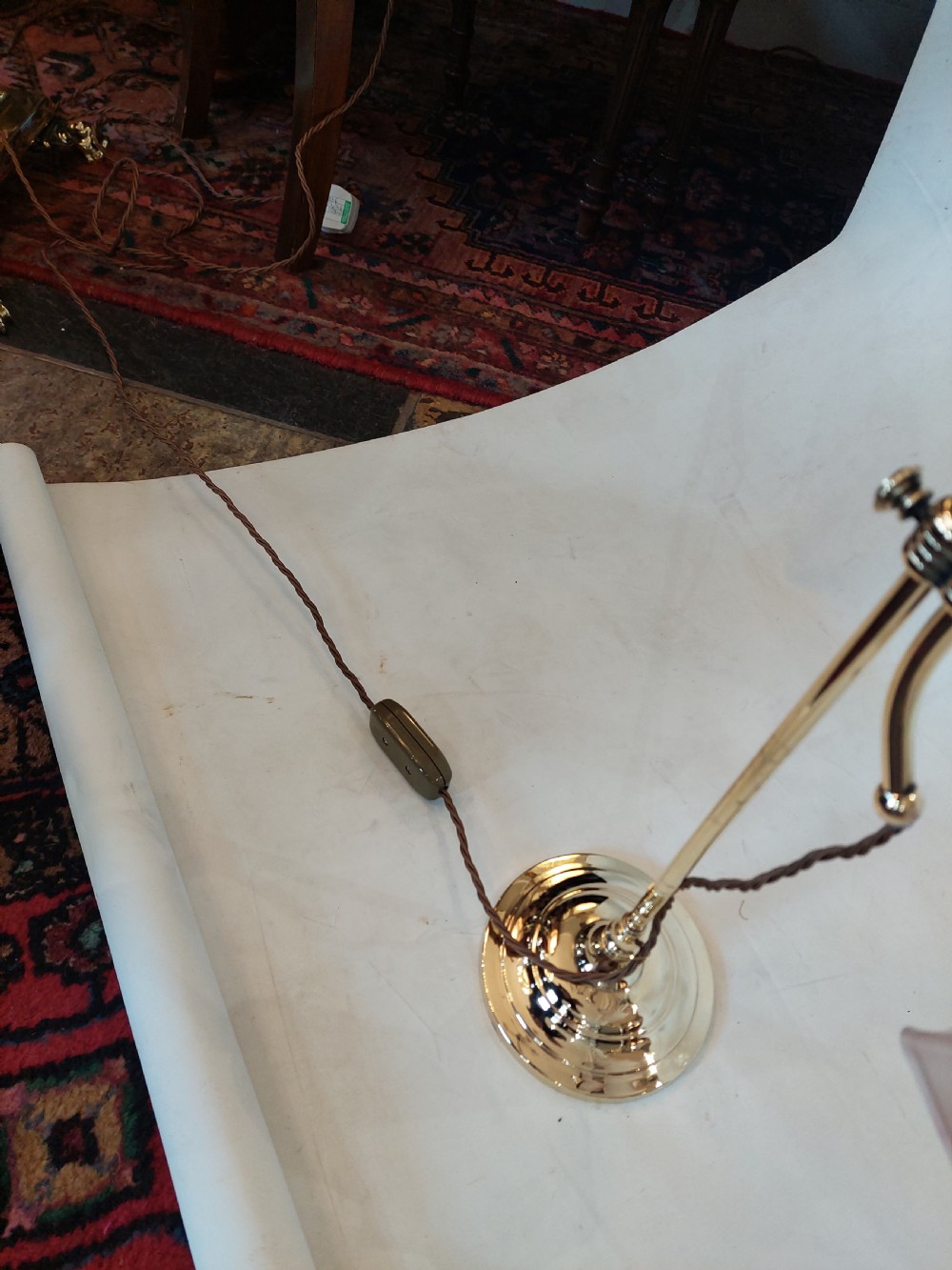 A pair of polished brass swan neck desk lamps with curved stems and frosted glass shades featuring pink fluted rims. View V