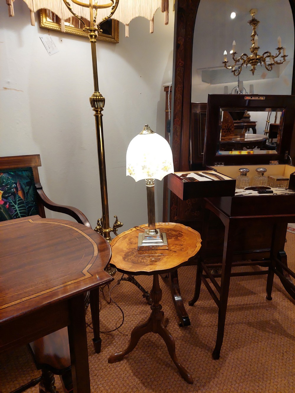 A polished brass table lamp designed as a fluted Corinthian column on a stepped square base, topped with a scalloped cream fabric shade decorated with embroidered floral motifs. View III