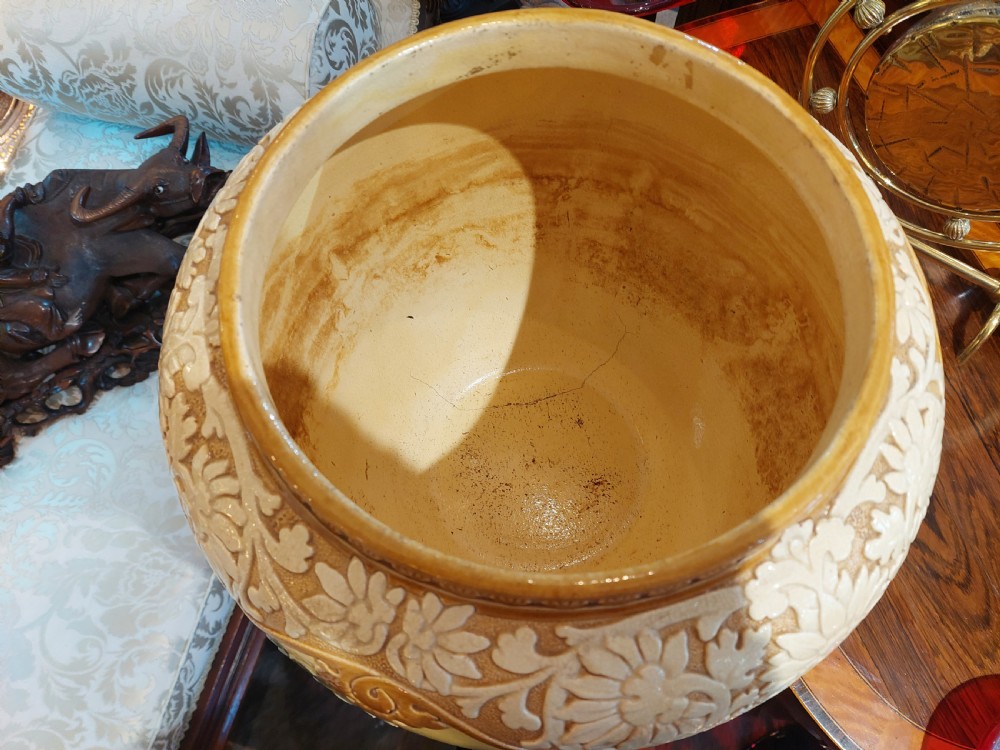 A Victorian Burmantofts majolica ceramic jardiniere and matching pedestal stand featuring painted floral panels and cream relief scrollwork on an ochre glaze. View III
