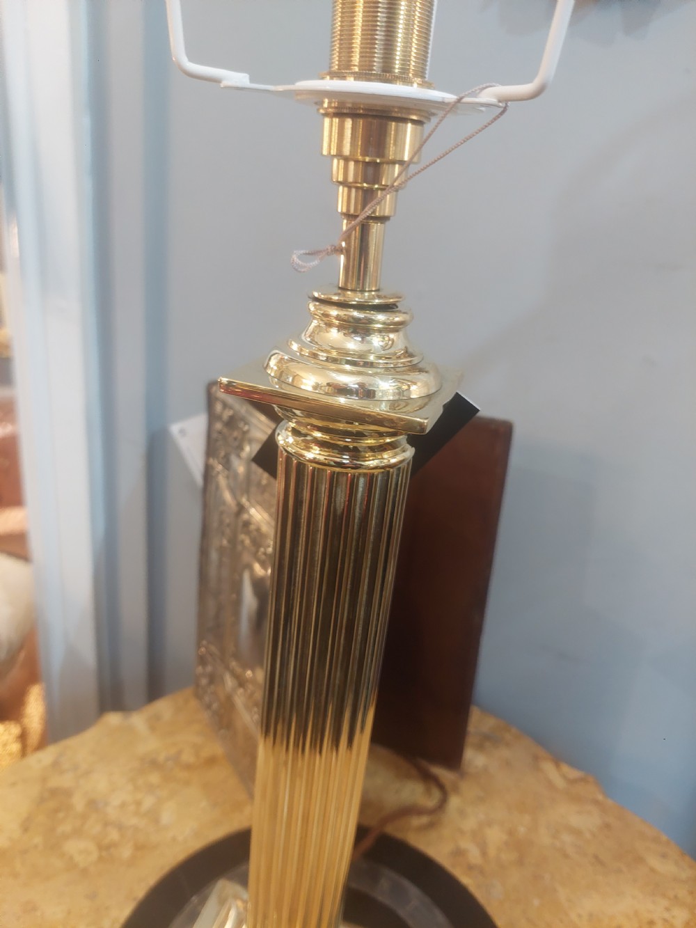 An early 20th-century brass table lamp featuring a reeded Doric column base and a patterned fabric lampshade with dark blue fringe and crystal drop beads. View III