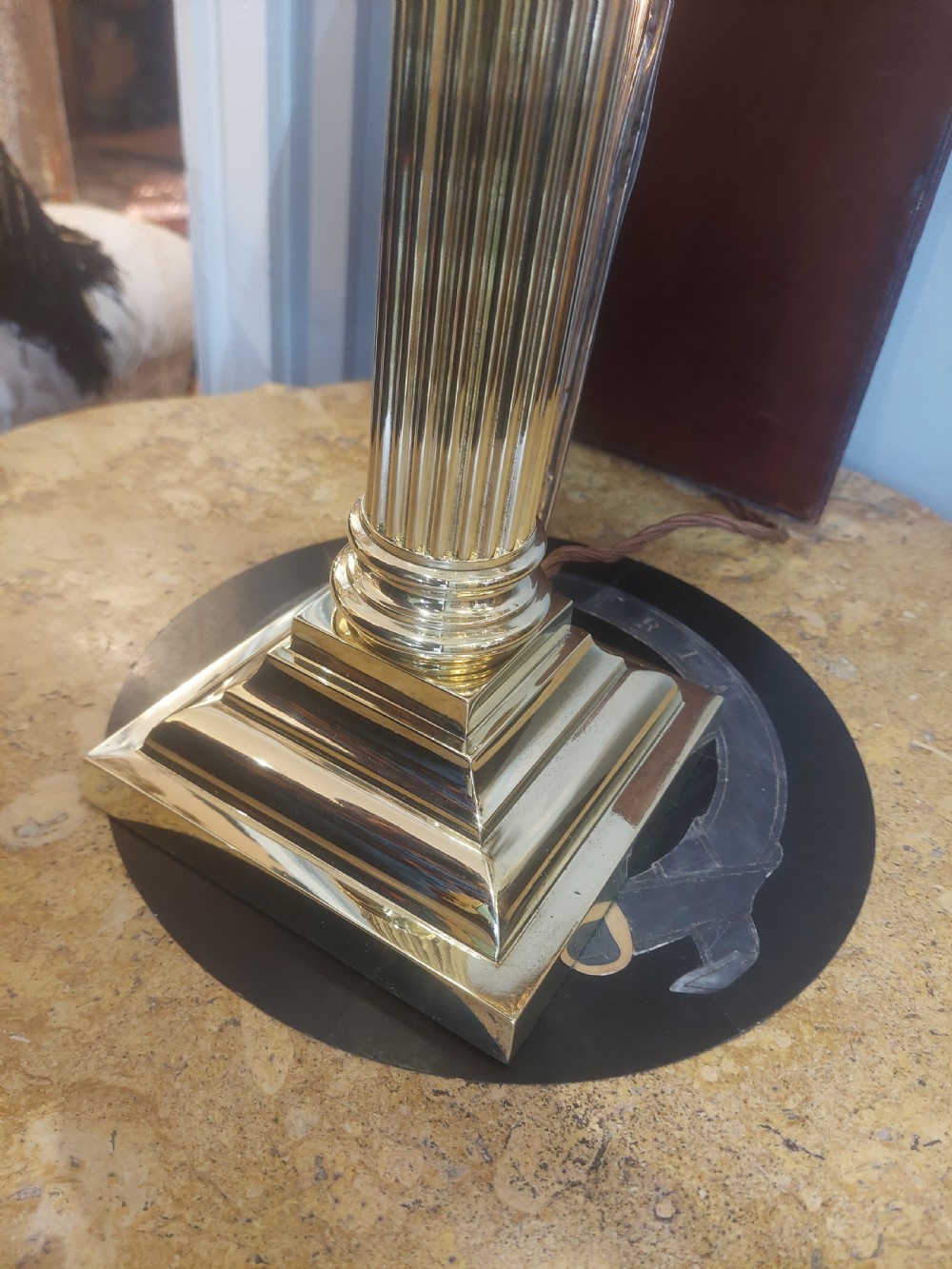An early 20th-century brass table lamp featuring a reeded Doric column base and a patterned fabric lampshade with dark blue fringe and crystal drop beads. View VII