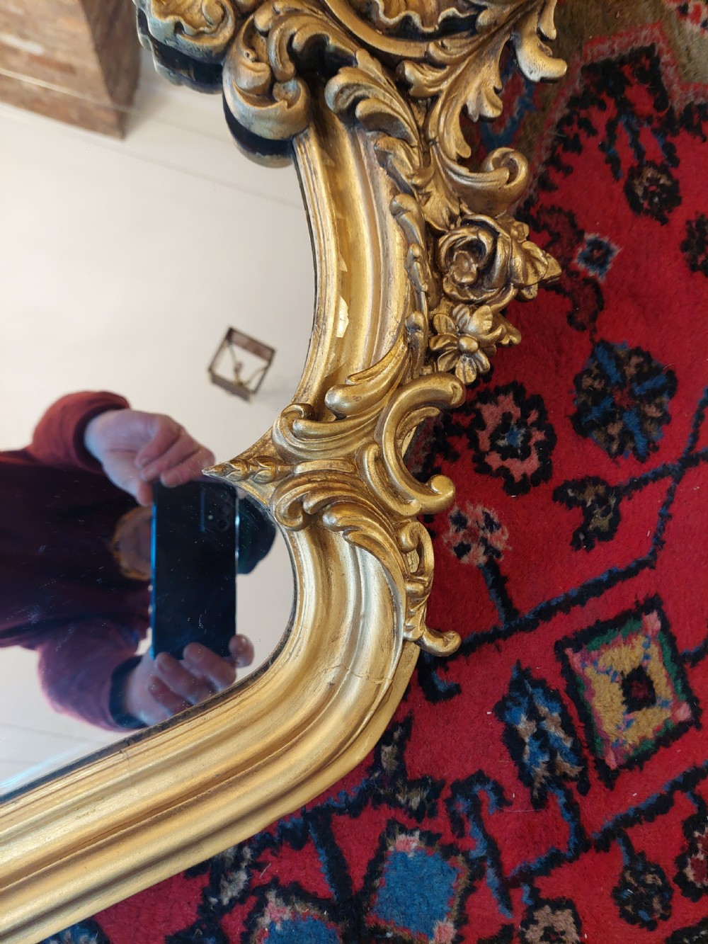 A Victorian giltwood overmantel mirror featuring an arched frame topped with an intricate rococo cresting of acanthus leaves and shell motifs. View VI