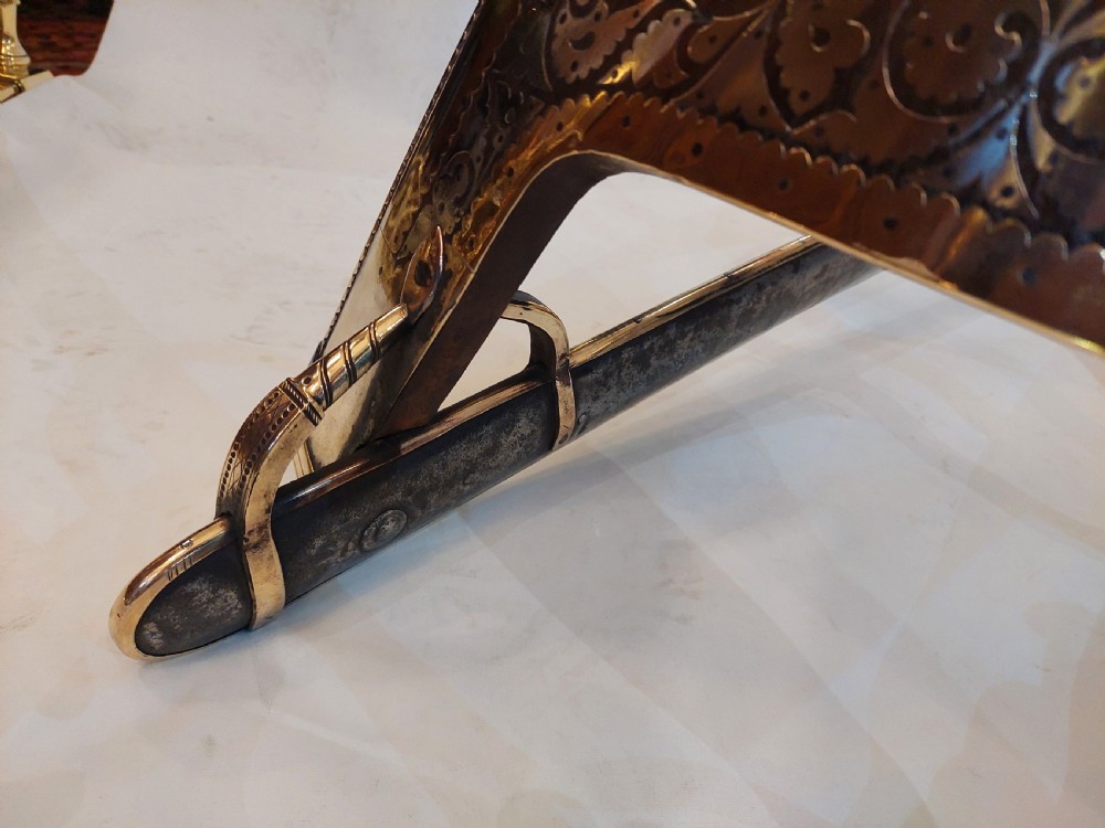 An antique ceremonial camel saddle frame featuring arched pommels clad in chased brass and silvered metal with floral engraving. View III