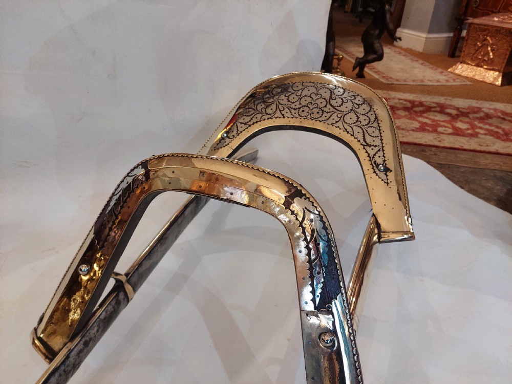 An antique ceremonial camel saddle frame featuring arched pommels clad in chased brass and silvered metal with floral engraving. View IV