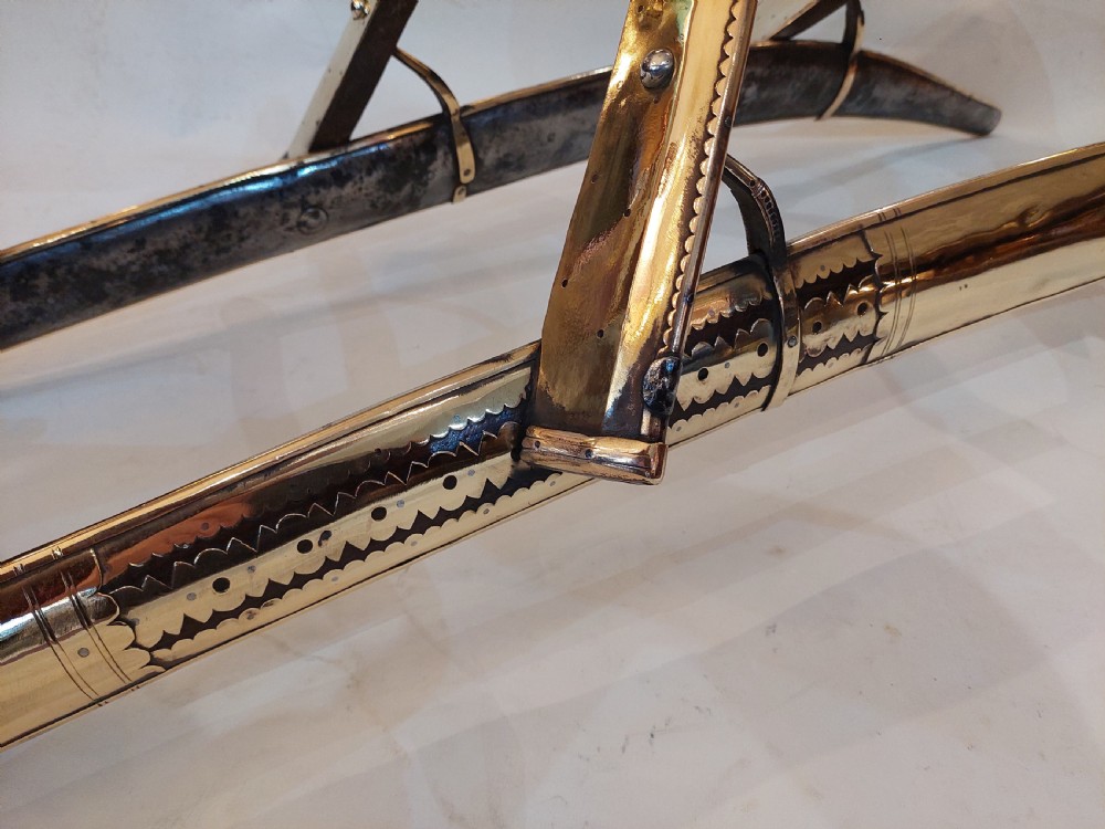 An antique ceremonial camel saddle frame featuring arched pommels clad in chased brass and silvered metal with floral engraving. View VII