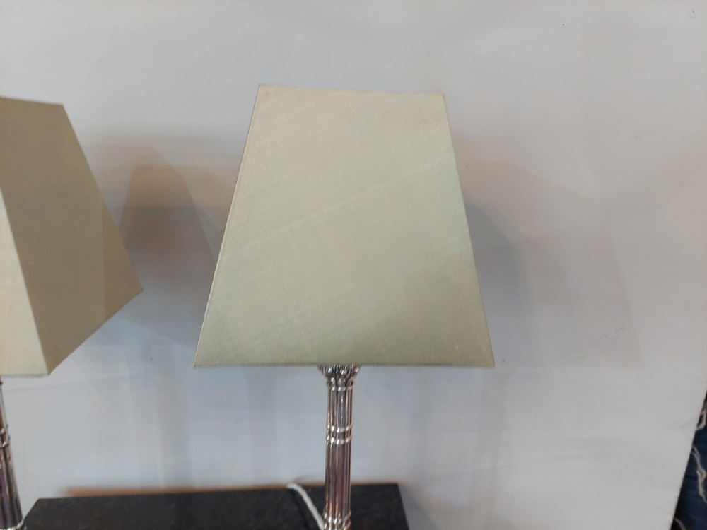 A pair of silver-plated table lamps designed as fluted classical columns with square relief-carved bases and cream square fabric lampshades. View VII