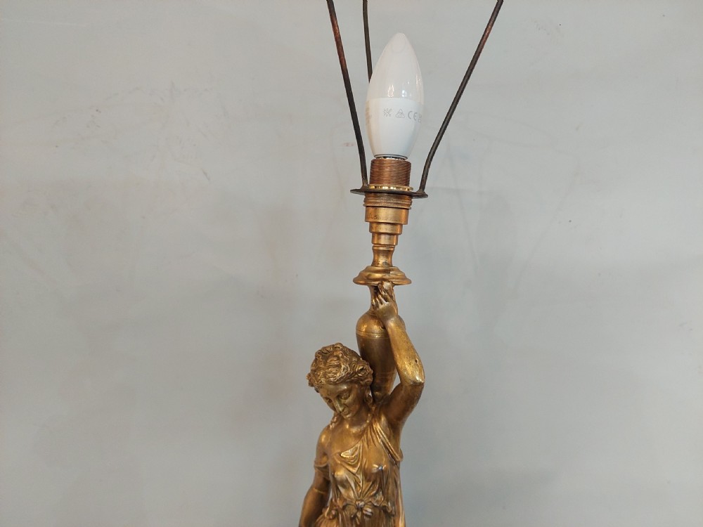 An antique Victorian cold-painted bronze table lamp shaped as a classical standing female figure on a green marble base, topped with a pink silk fringed shade. View III