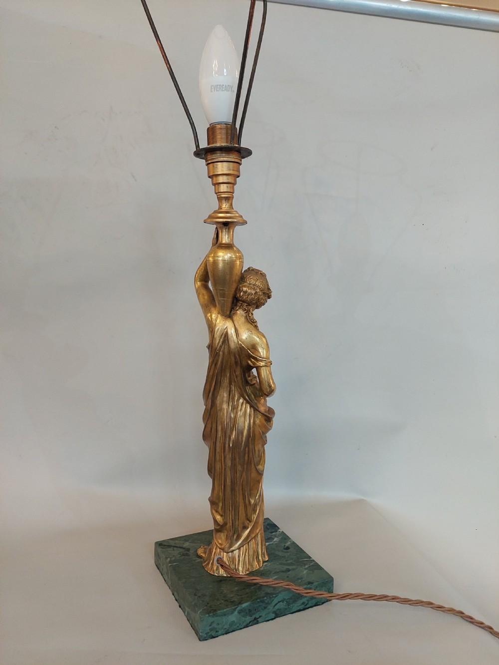 An antique Victorian cold-painted bronze table lamp shaped as a classical standing female figure on a green marble base, topped with a pink silk fringed shade. View VIII