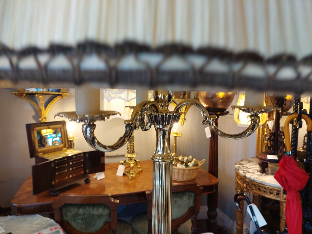 A pair of 1920s polished brass standard floor lamps featuring reeded columns, decorative cast bases, and pleated fabric shades. View III