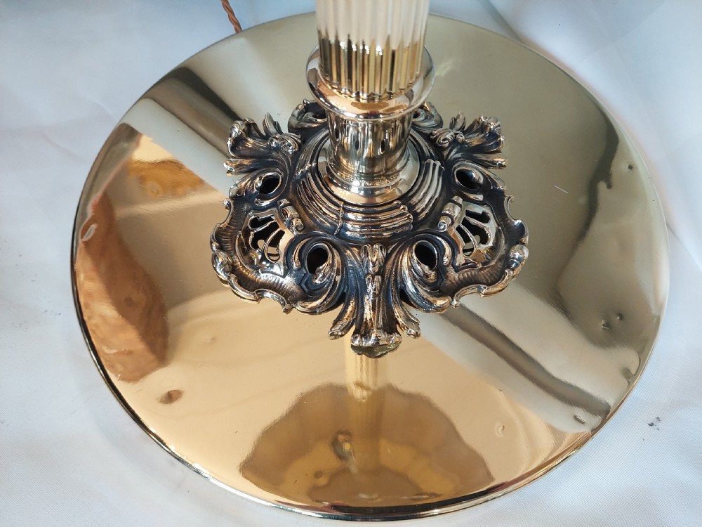 A pair of 1920s polished brass standard floor lamps featuring reeded columns, decorative cast bases, and pleated fabric shades. View VII