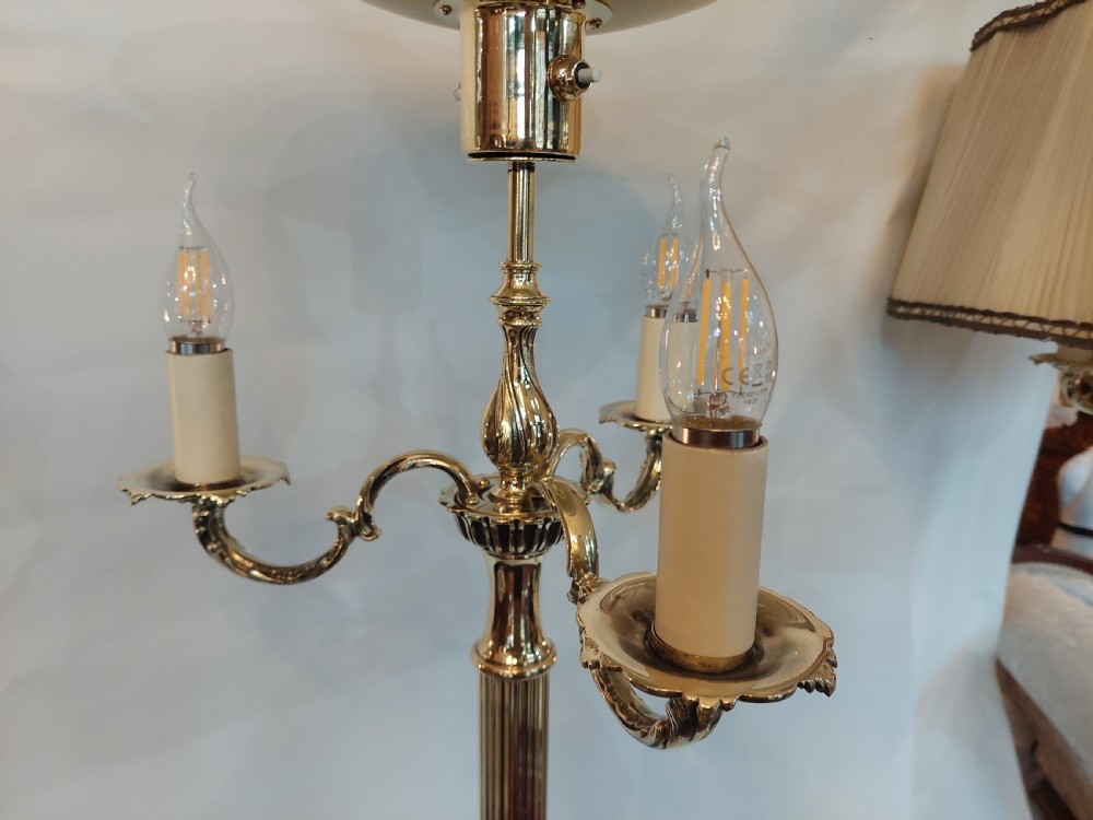 A pair of 1920s polished brass standard floor lamps featuring reeded columns, decorative cast bases, and pleated fabric shades. View VIII