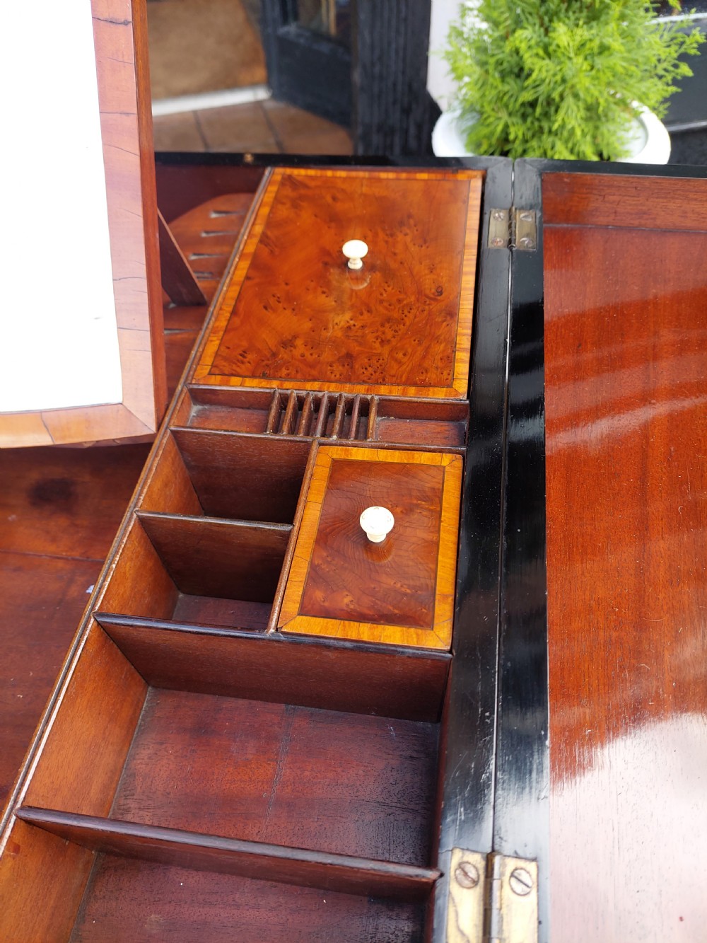 A George III satinwood and mahogany gentlemans wash stand with extended hinged top flaps, an upright central mirror, and tapered inlaid legs on brass castors. View IV