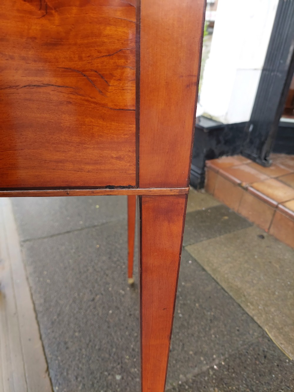 A George III satinwood and mahogany gentlemans wash stand with extended hinged top flaps, an upright central mirror, and tapered inlaid legs on brass castors. View XII
