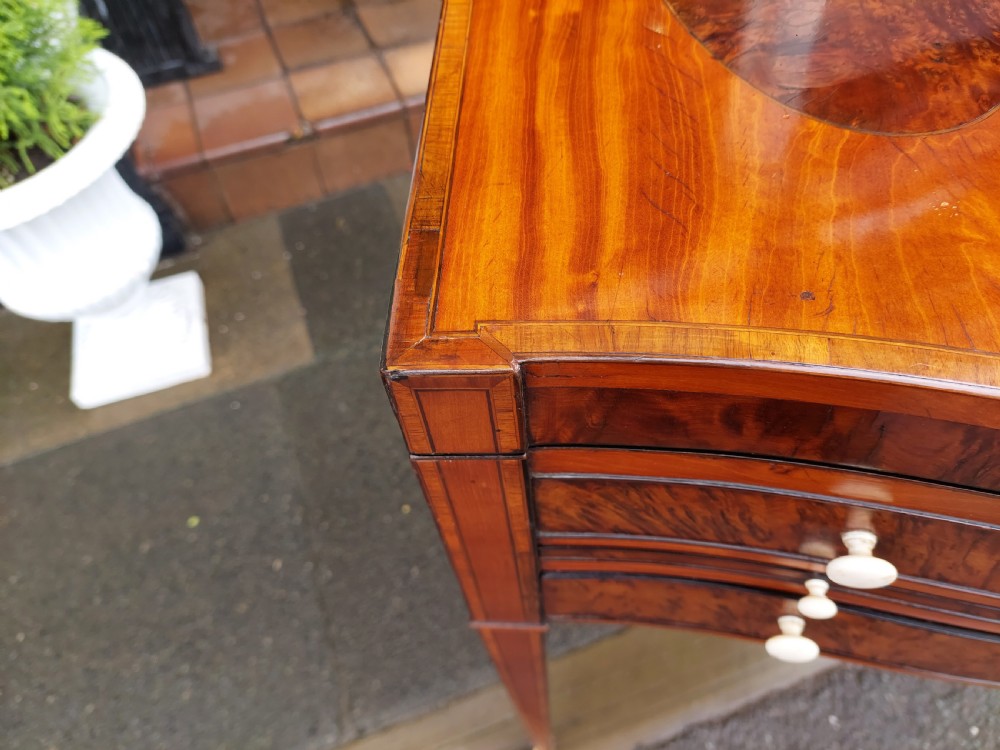 A George III satinwood and mahogany gentlemans wash stand with extended hinged top flaps, an upright central mirror, and tapered inlaid legs on brass castors. View XIV
