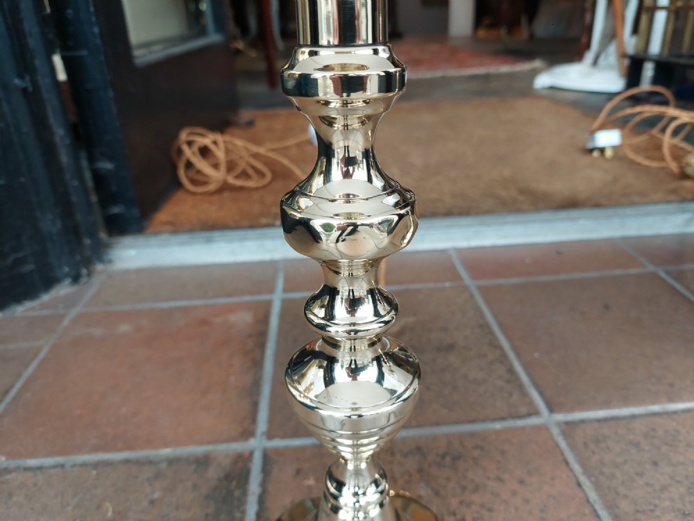 A pair of turned Victorian-style polished brass table lamps fitted with white conical lampshades. View IV