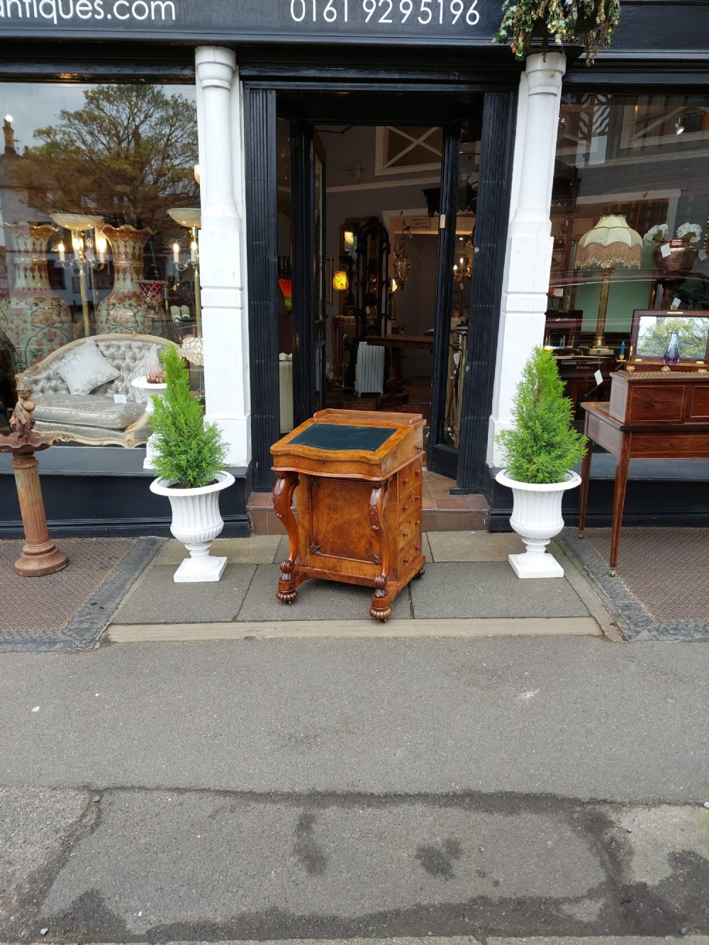 A Victorian burr walnut Davenport desk featuring a green leather sloped writing surface, carved cabriole front supports, and side drawers on castors. View II