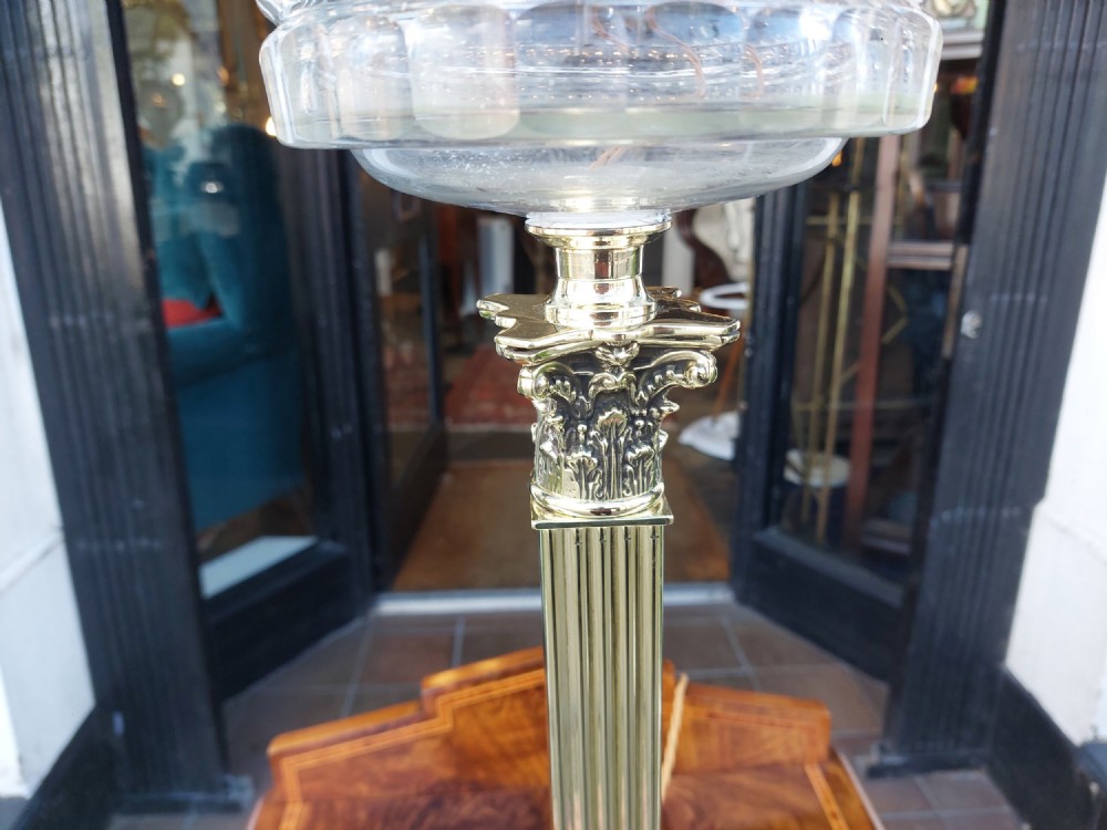A Victorian brass oil lamp featuring a fluted Corinthian column base, a clear glass reservoir, and an etched spherical glass shade. View V
