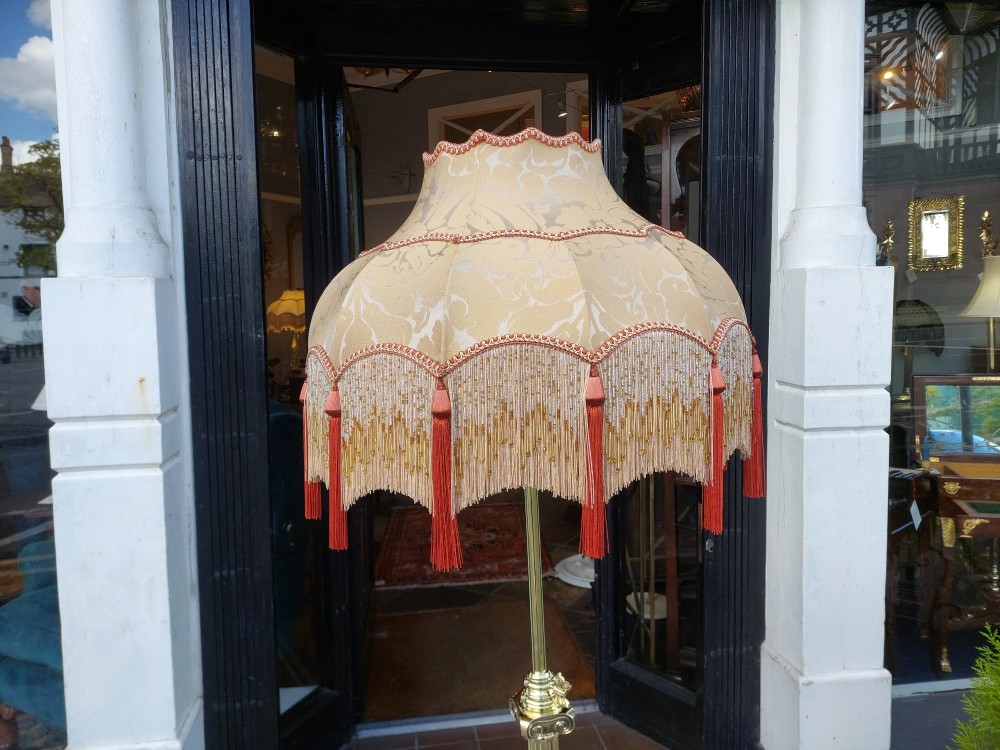 A Victorian Neoclassical brass floor lamp featuring a fluted column shaft, Corinthian capital detail, stepped base on claw feet, and a cream fringed fabric shade. View II