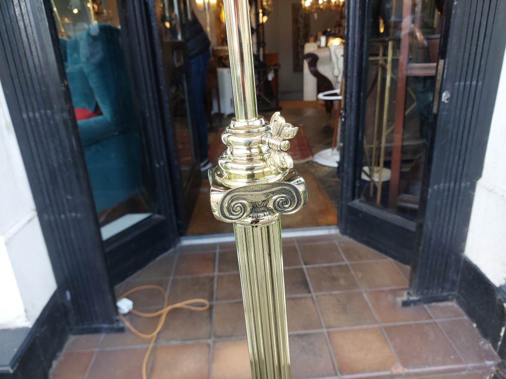 A Victorian Neoclassical brass floor lamp featuring a fluted column shaft, Corinthian capital detail, stepped base on claw feet, and a cream fringed fabric shade. View IV