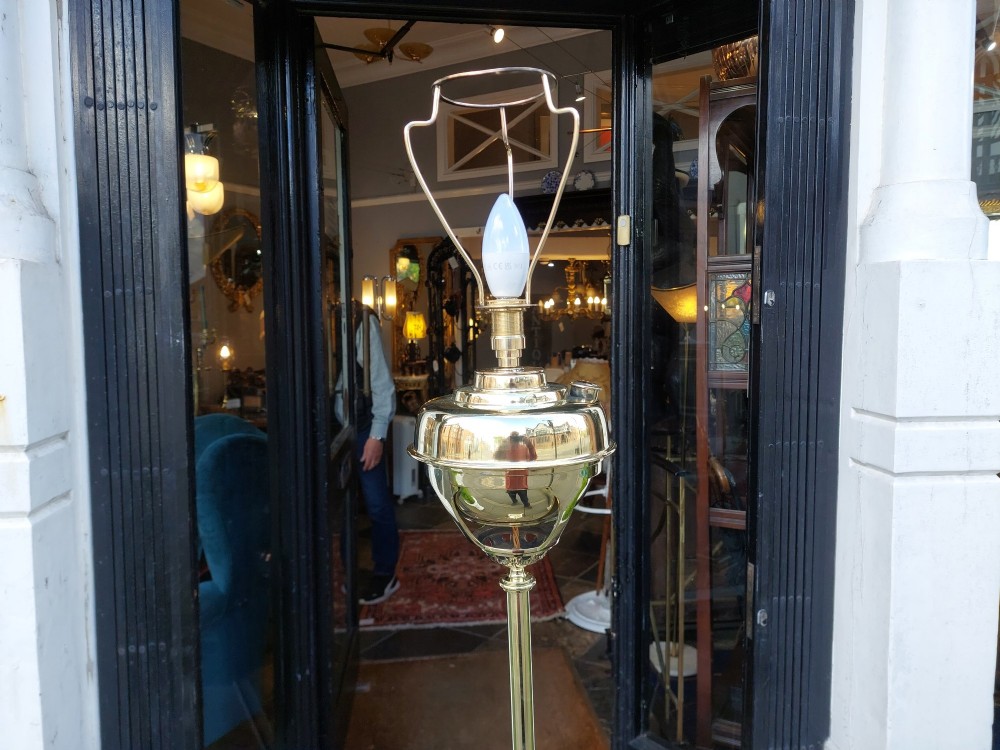 A Victorian Neoclassical brass floor lamp featuring a fluted column shaft, Corinthian capital detail, stepped base on claw feet, and a cream fringed fabric shade. View IX