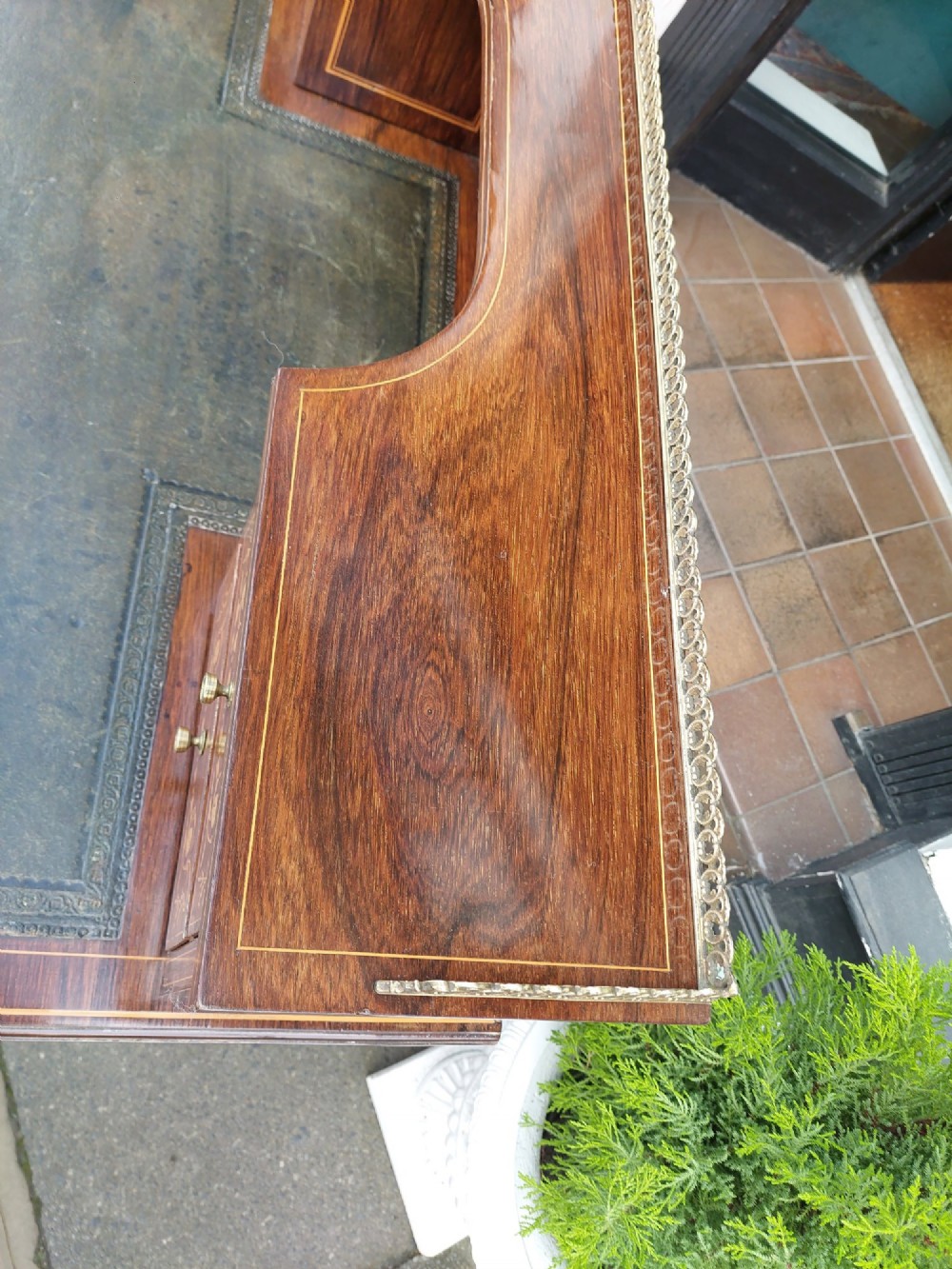 Late Victorian inlaid mahogany writing desk featuring an upper mirror-backed superstructure with brass gallery, leather writing surface, floral marquetry, and tapered legs on castors. View II