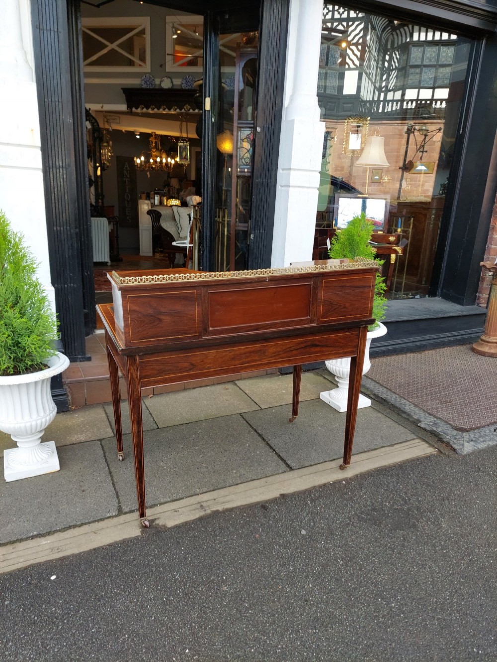 Late Victorian inlaid mahogany writing desk featuring an upper mirror-backed superstructure with brass gallery, leather writing surface, floral marquetry, and tapered legs on castors. View XII