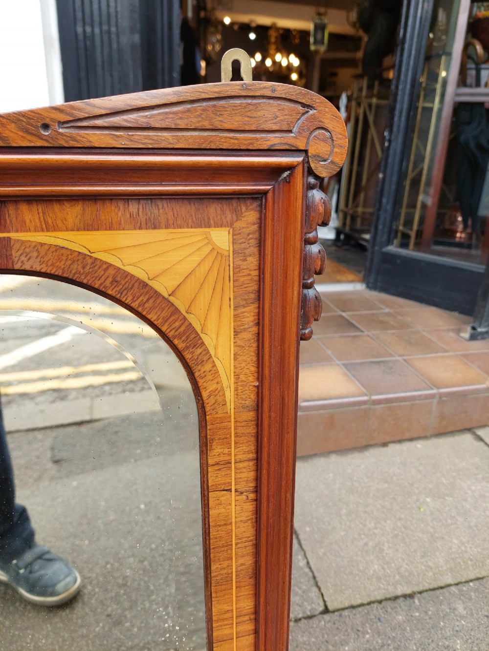 An Edwardian rosewood rectangular overmantel mirror featuring decorative marquetry inlays in the upper corners, a central carved cresting, and a bevelled glass plate. View III