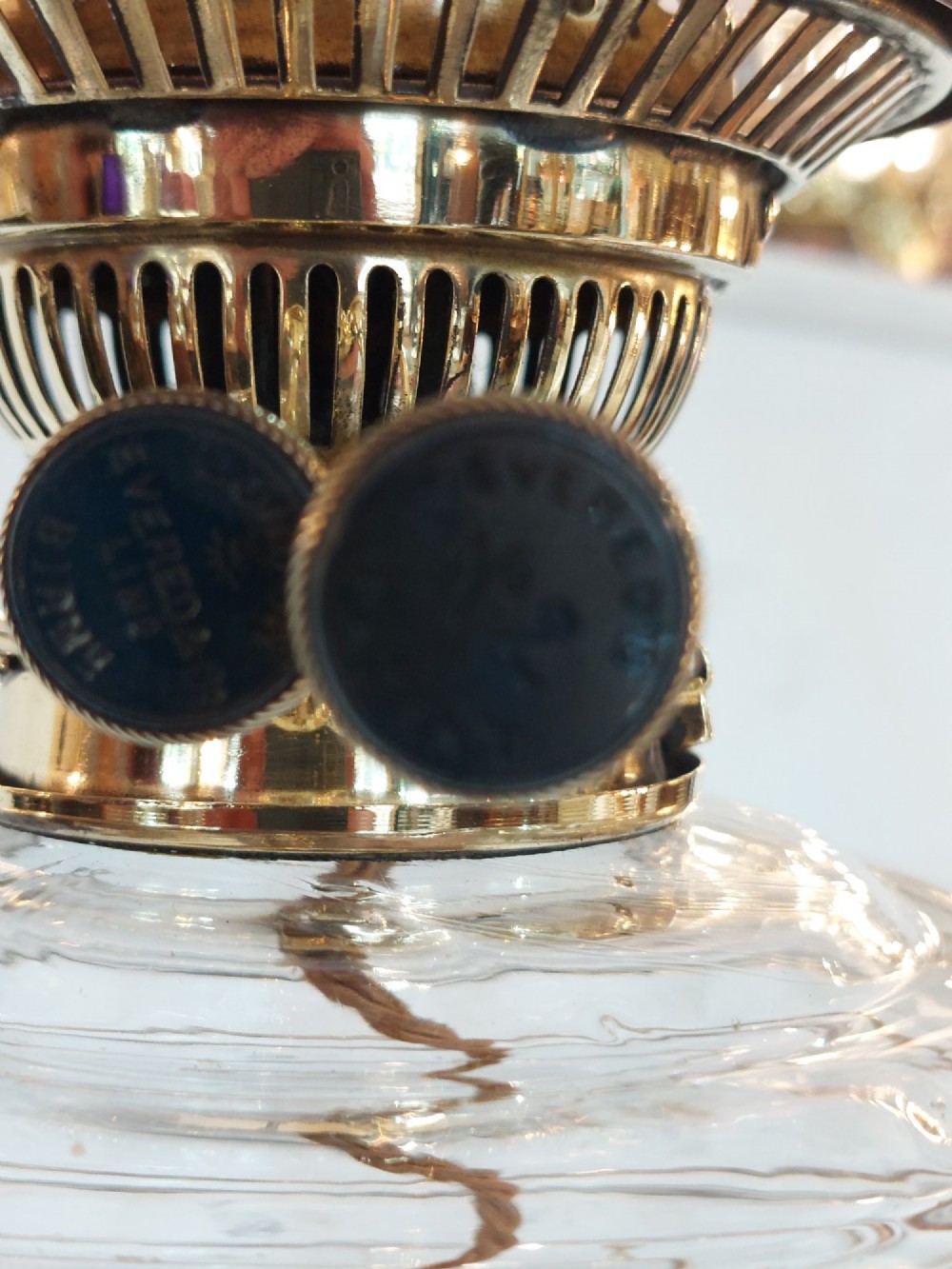 A late 19th-century brass table oil lamp featuring a reeded column, square base, clear glass reservoir, and an etched pink glass shade with a ruffled rim. View VI