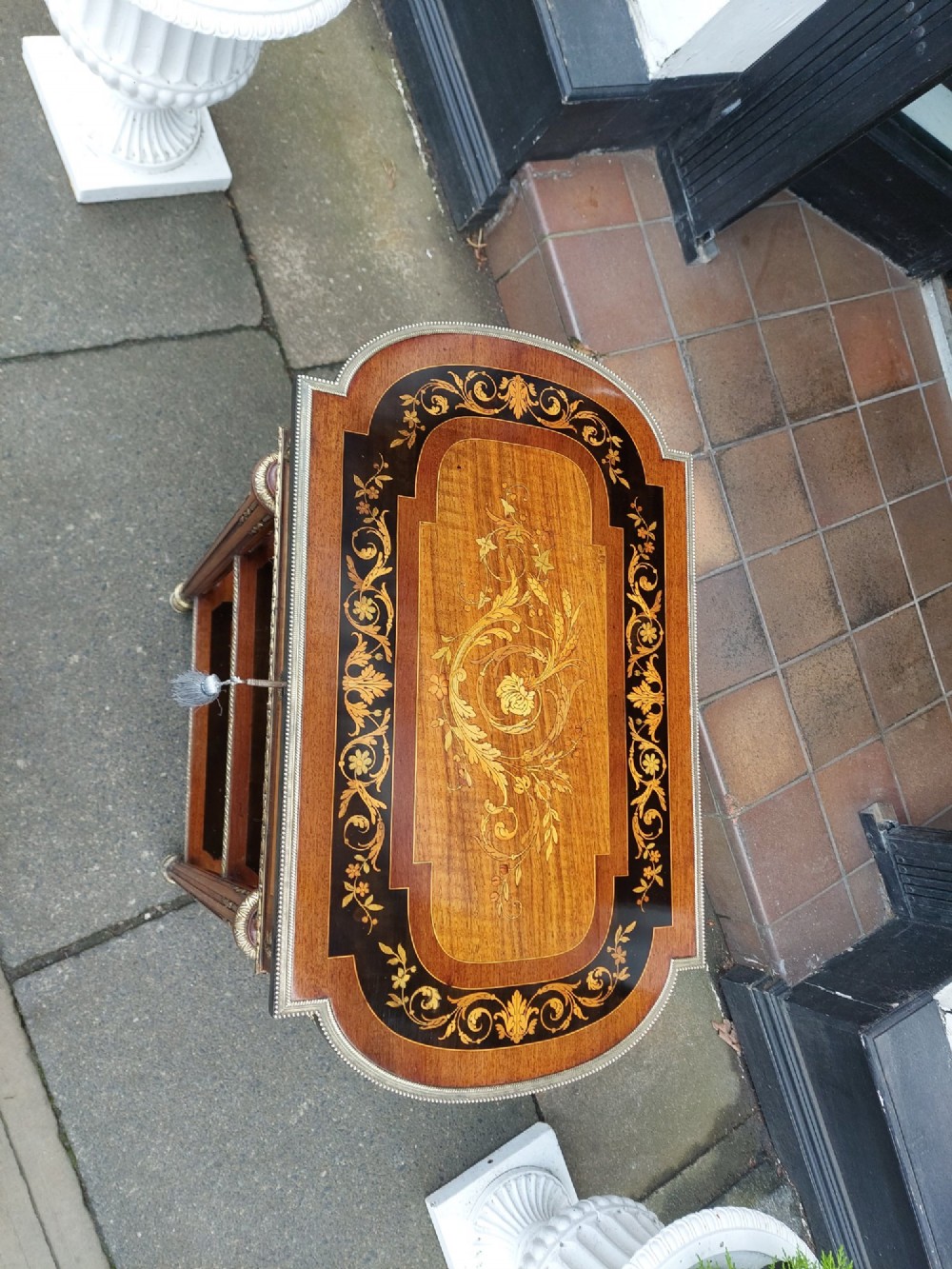 An antique Victorian marquetry whatnot table featuring floral inlay on the top surface, two lower tiers, fluted legs, and gilt-metal mounts. View III