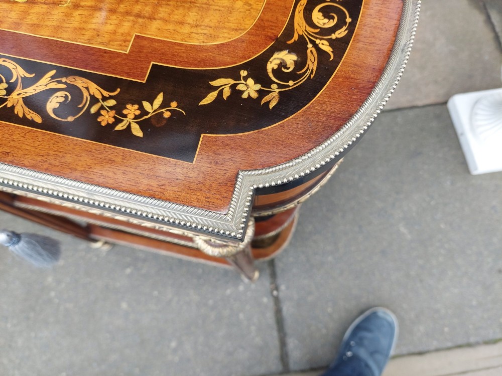 An antique Victorian marquetry whatnot table featuring floral inlay on the top surface, two lower tiers, fluted legs, and gilt-metal mounts. View V