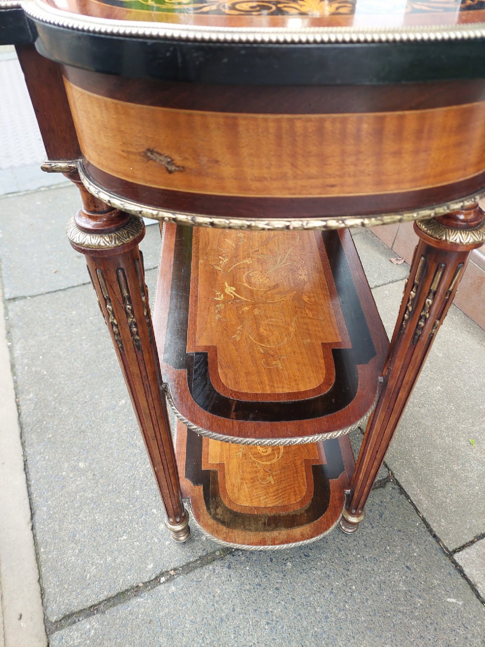 An antique Victorian marquetry whatnot table featuring floral inlay on the top surface, two lower tiers, fluted legs, and gilt-metal mounts. View VI