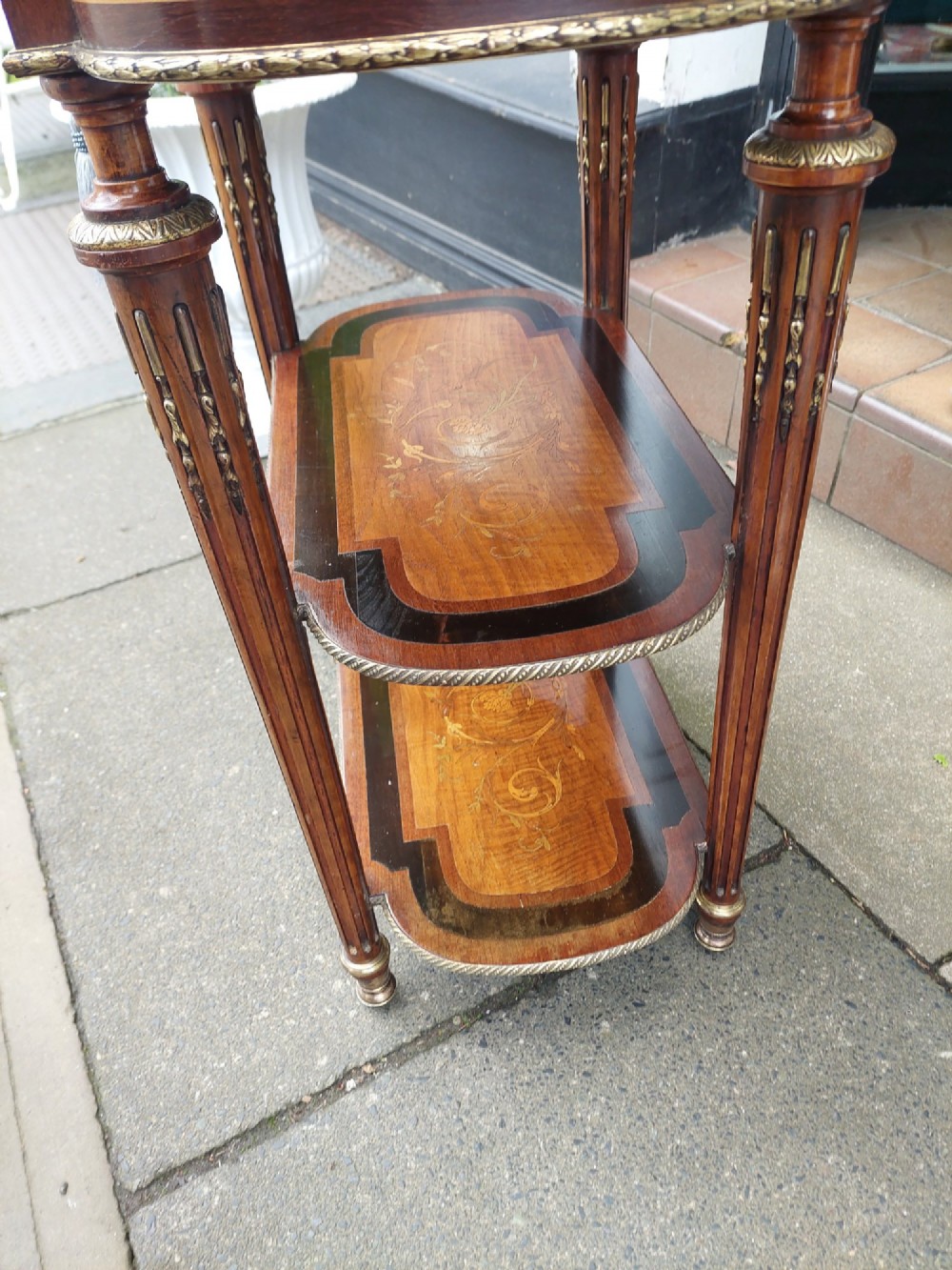 An antique Victorian marquetry whatnot table featuring floral inlay on the top surface, two lower tiers, fluted legs, and gilt-metal mounts. View VII