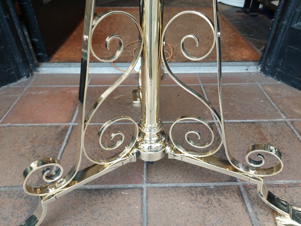 An Edwardian brass standard floor lamp featuring a scrollwork tripod base, an integrated circular tray table, and a fabric shade with fringe and tassels. View IV