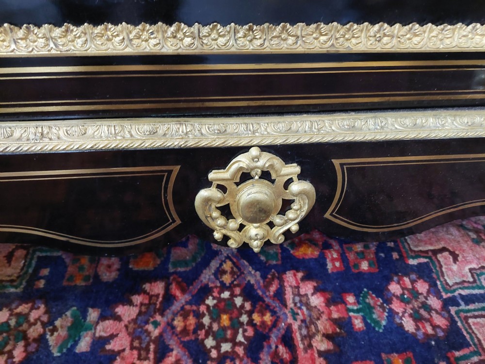 A French Napoleon III ebonised side cabinet featuring a white marble top, gold brass inlays, gilt-bronze ormolu mounts, and a central oval medallion. View VIII