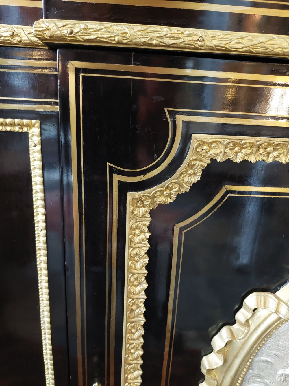 A French Napoleon III ebonised side cabinet featuring a white marble top, gold brass inlays, gilt-bronze ormolu mounts, and a central oval medallion. View X