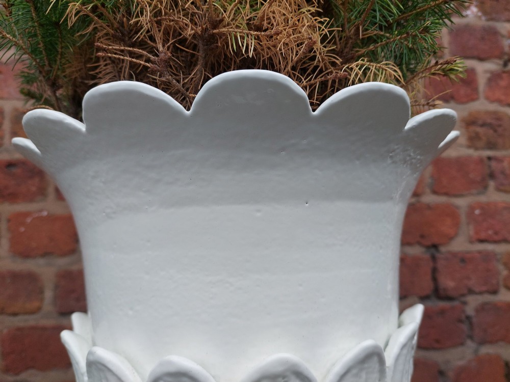 A classical white painted garden urn featuring an acanthus leaf pattern and scalloped rim, positioned on a matching square pedestal stand. View V